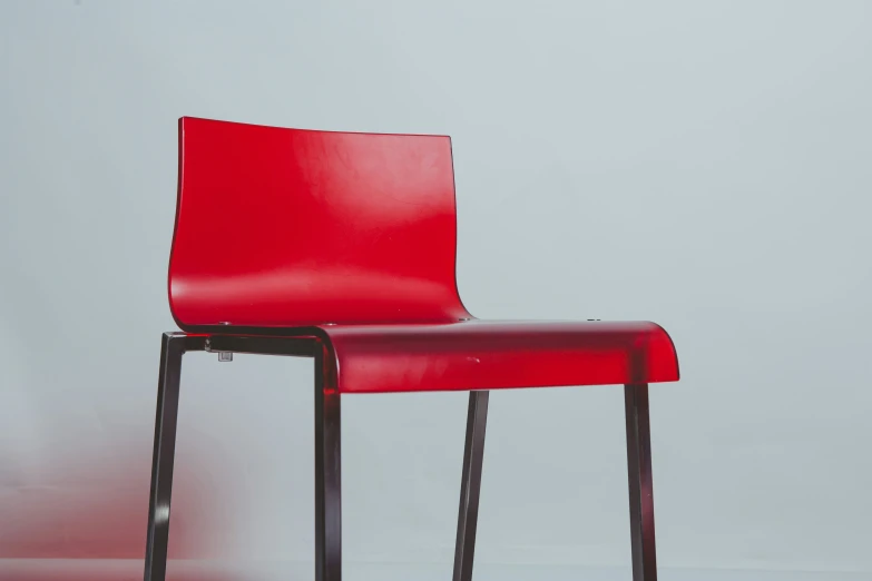 a red chair sitting in front of a white wall