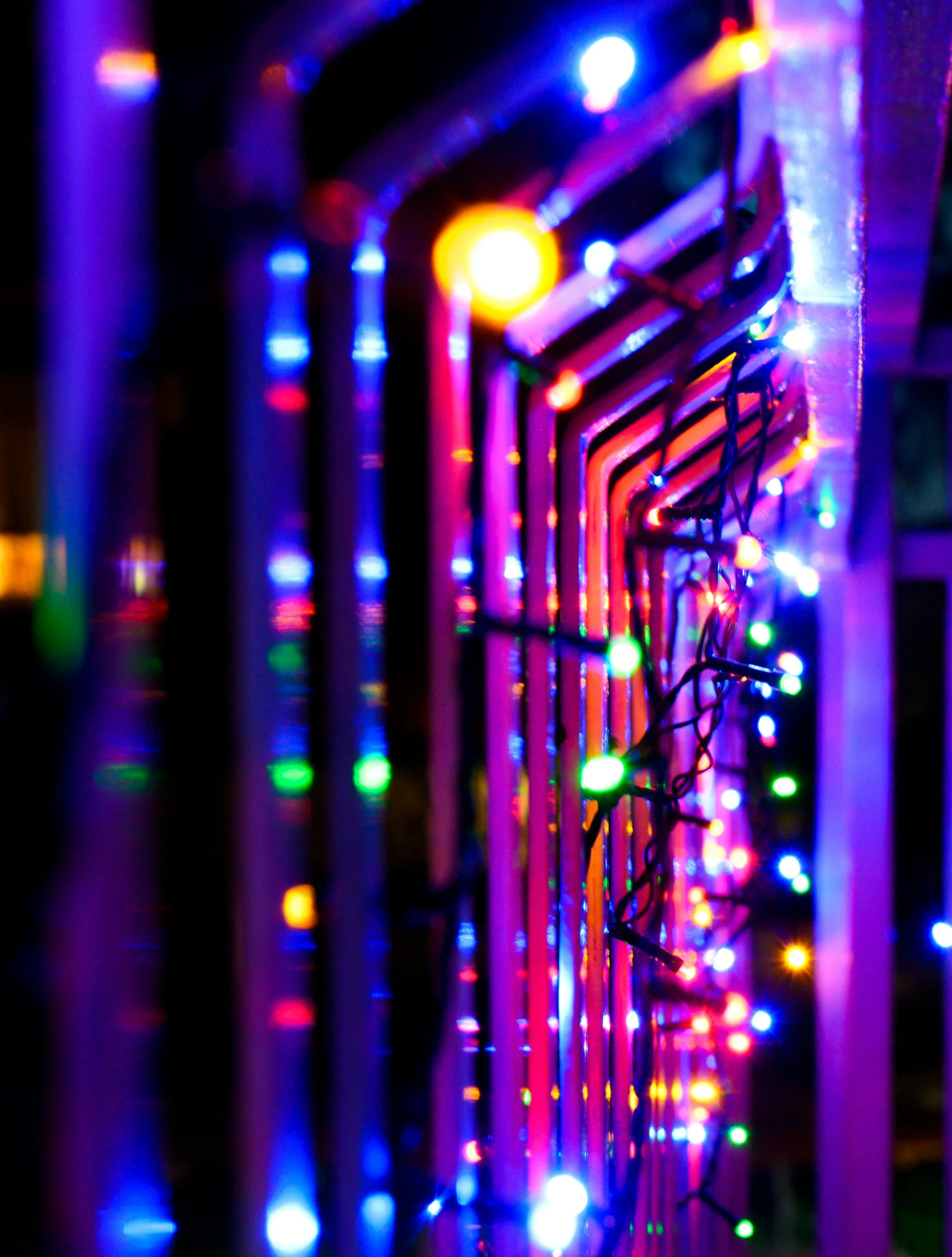 many colored lights strung on a building near a window