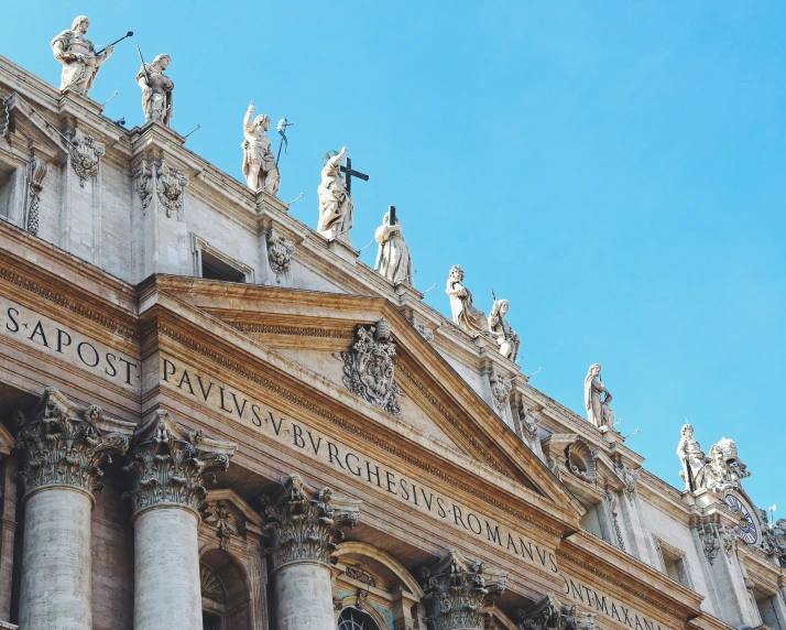 a building with statues on it has tall windows