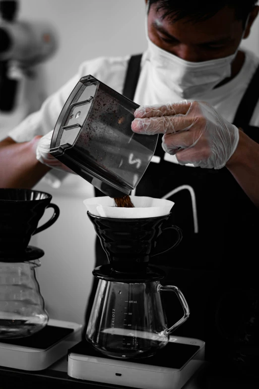 a man in an apron pours a cup of coffee