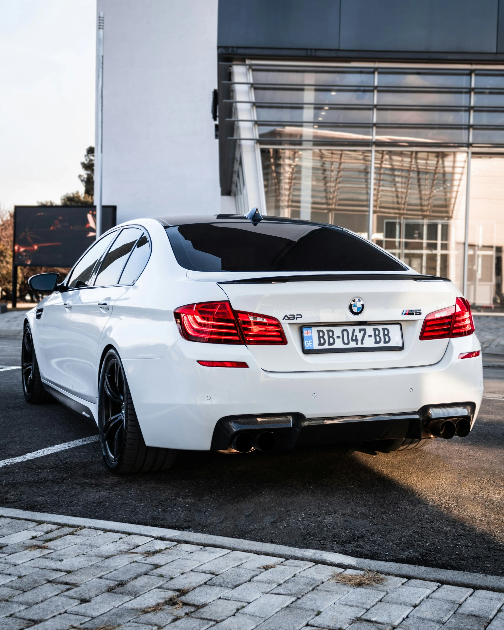 white bmw coupe with an awning parked on the street