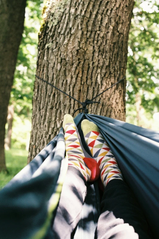someone laying in a hammock and holding their feet up