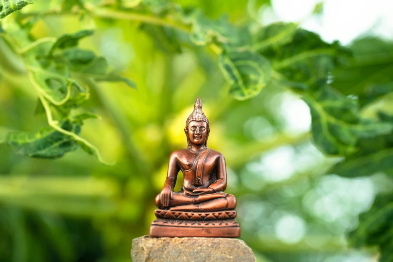 a small wooden buddha figure sitting on top of rocks