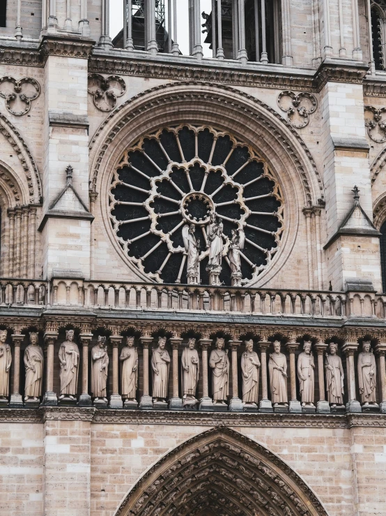 a cathedral tower with stone carvings and a sculpture of a man