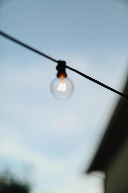 the light bulb is hanging on a wire outside