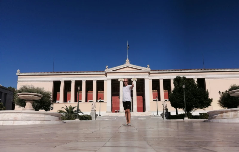 a person stands on the ground in front of a large building