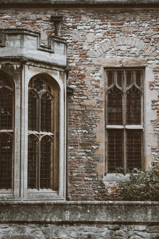 an old building with brick and two gothic windows