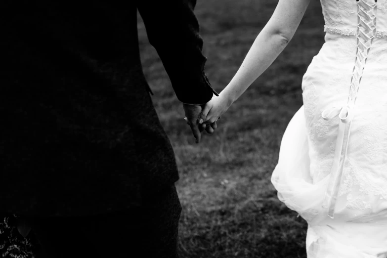 a man and a woman are standing holding hands