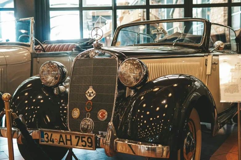 two antique style automobiles are parked next to each other