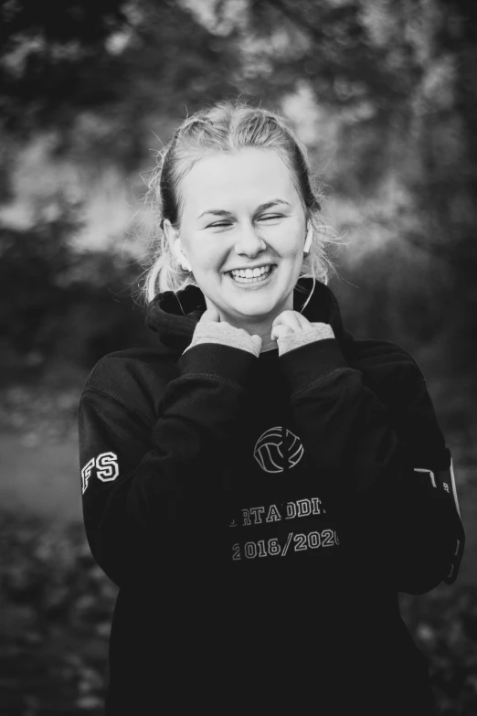 a girl in a black jacket posing for a picture