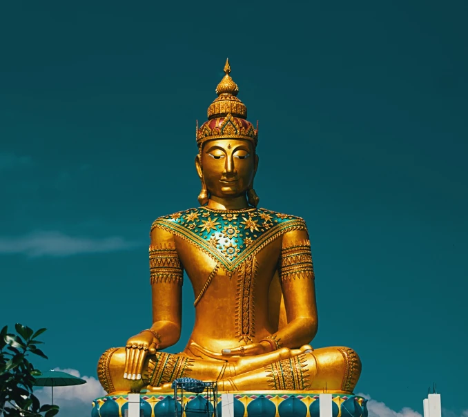 a golden statue sits in the air on top of a roof