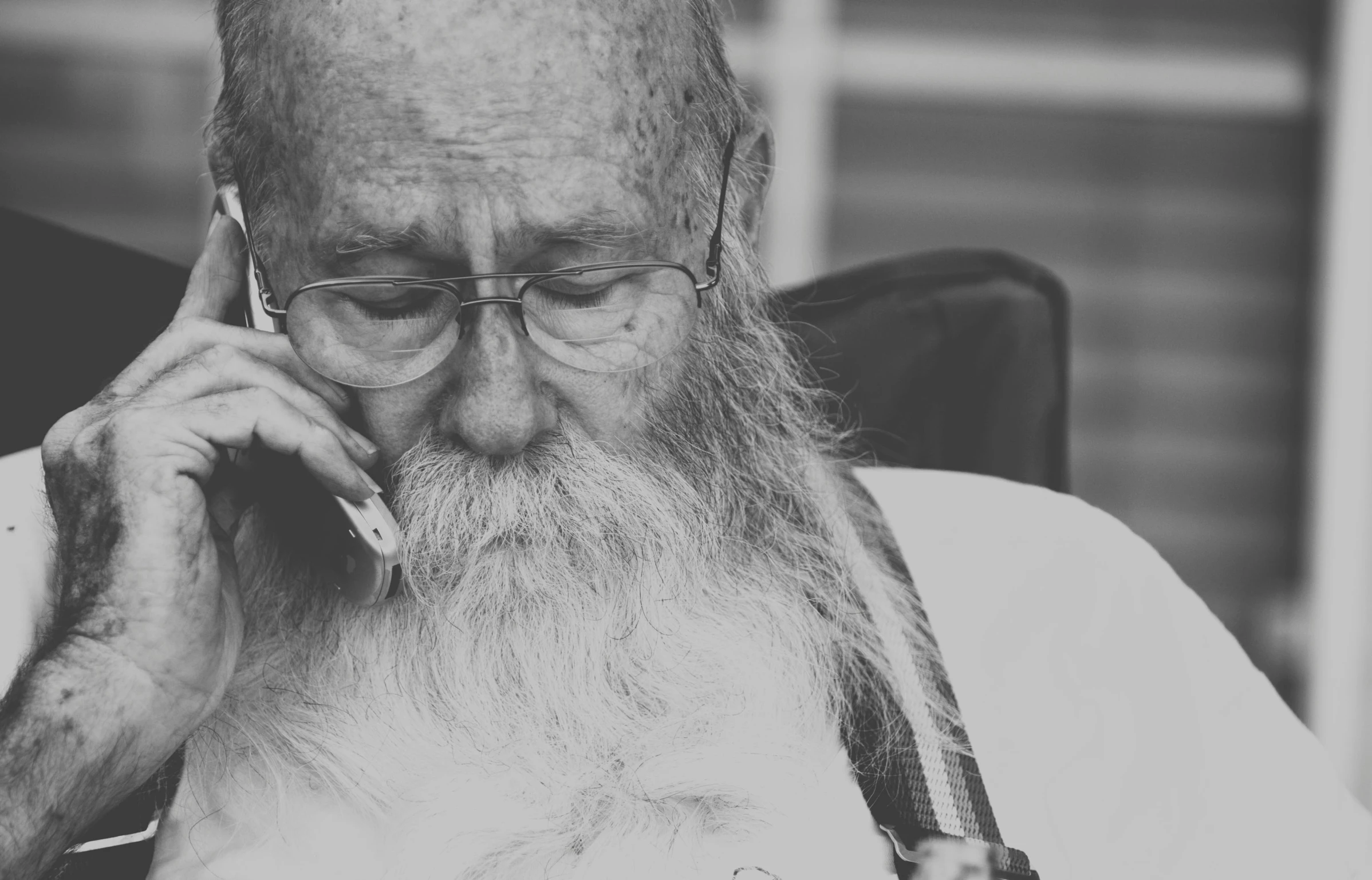 an old man talking on the telephone while smoking a pipe