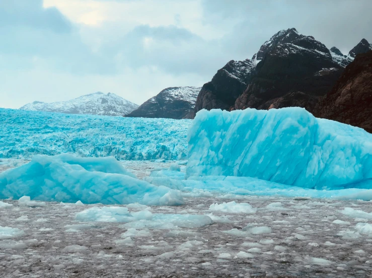 blue icebergs rise out from an icy lake