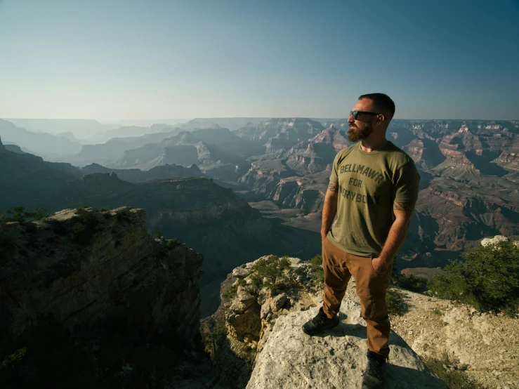 a man standing on the edge of a cliff at the grand canyon