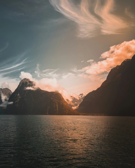 the view of mountains and clouds over water