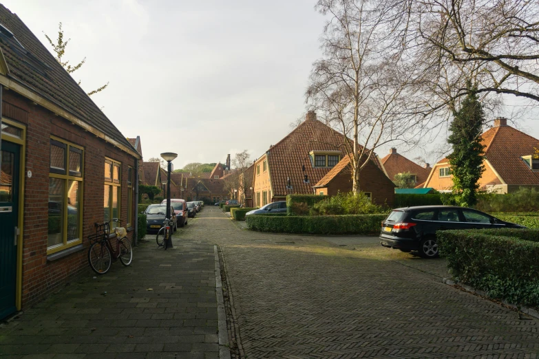 a long brick street lined with cars and bicycles