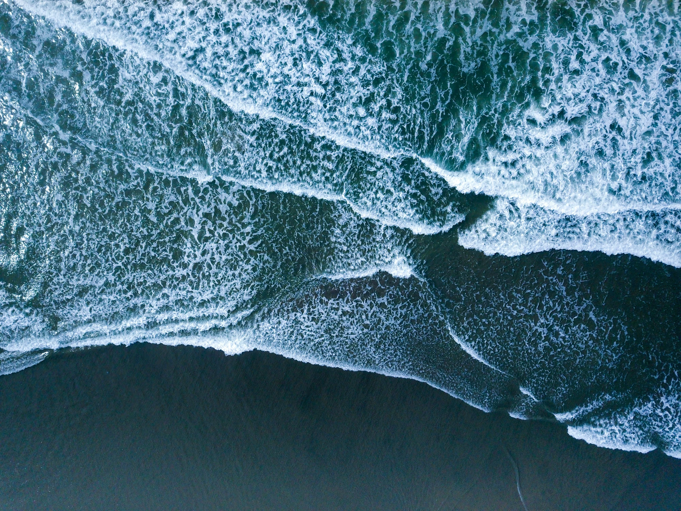 the beach is covered in blue water and waves