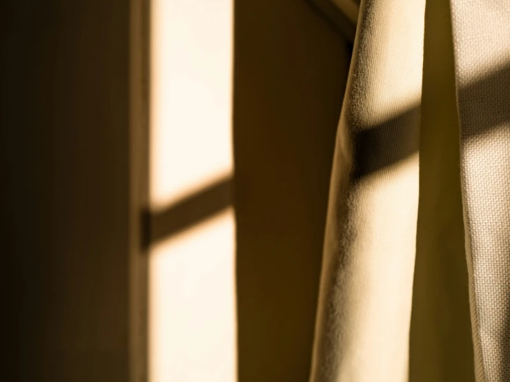 sunlight coming in through curtains onto a wall