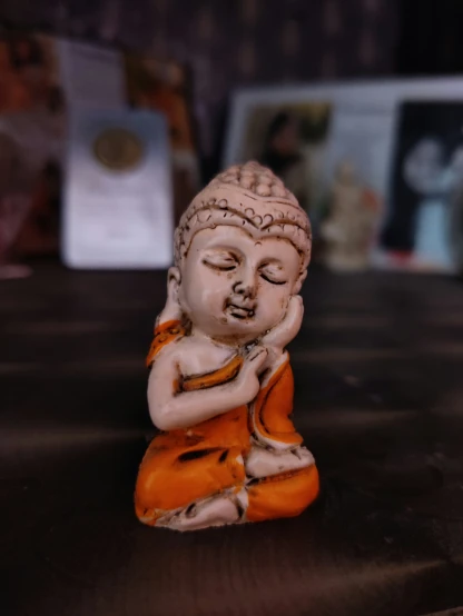an antique ceramic buddha figure on a table