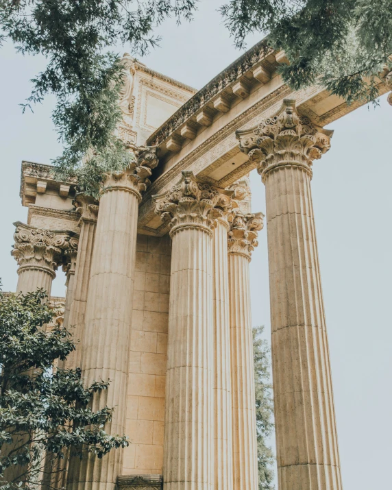 four columns and some trees in front of a building