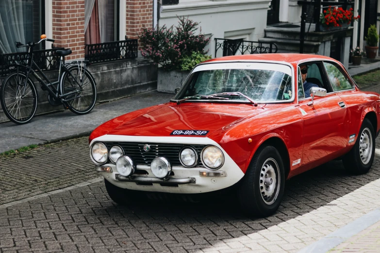 a vintage red and white car parked on the side of a street