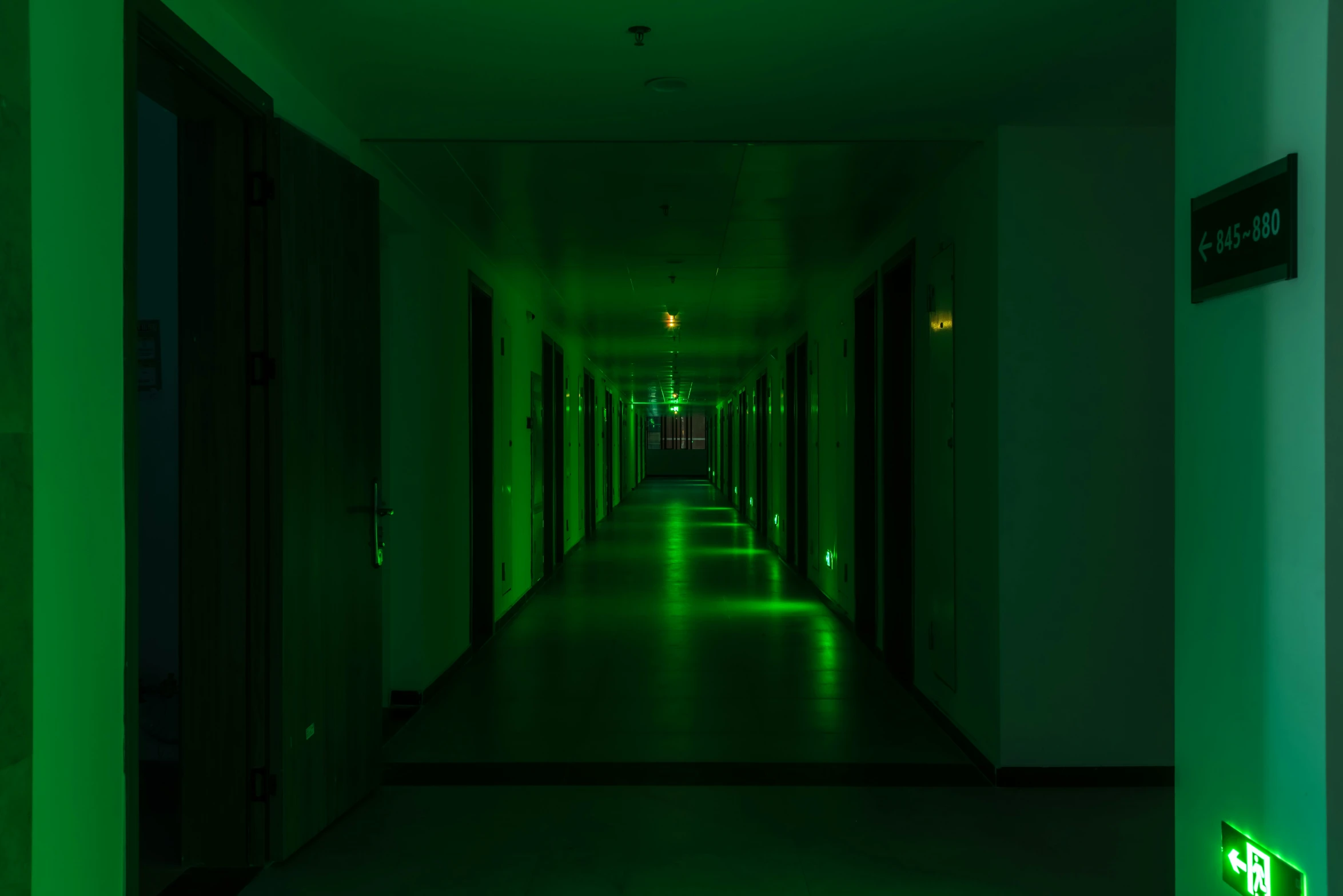 a long hallway with lights that are green