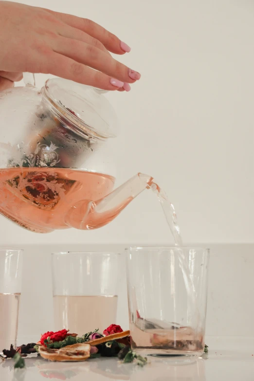 a person pouring water into a vase filled with flowers