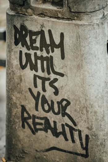 graffiti is on the wall that says, dream until it's your reality