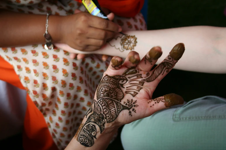 a woman with a henna holding her hands out