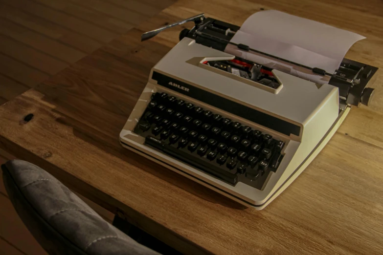 a grey typewriter and a wooden table top