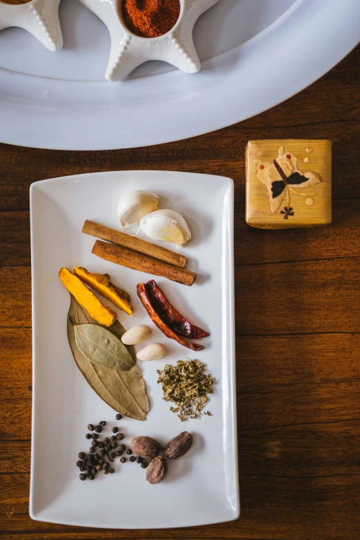 a plate of different spices on a wooden table