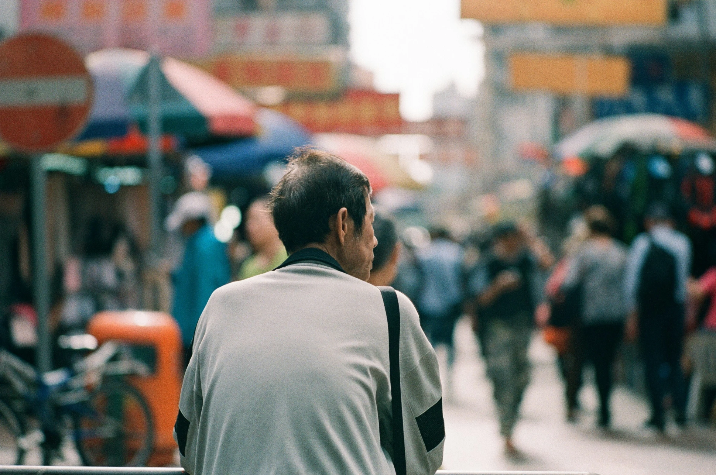 a man is looking down the sidewalk at a group of people