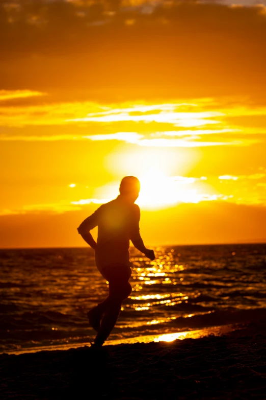 man running along the ocean at sunset or sunrise