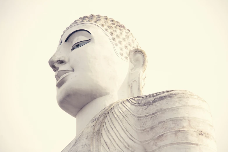 a white buddha statue with one large head