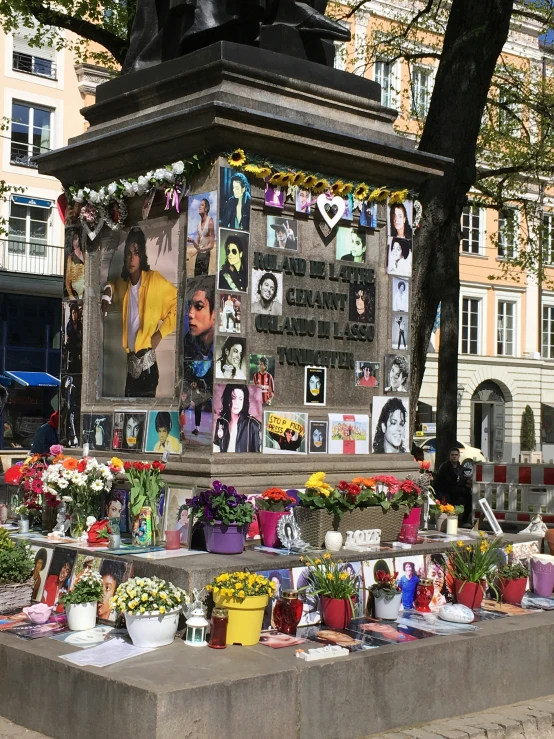 a man has a memorial in front of a monument with pictures on it