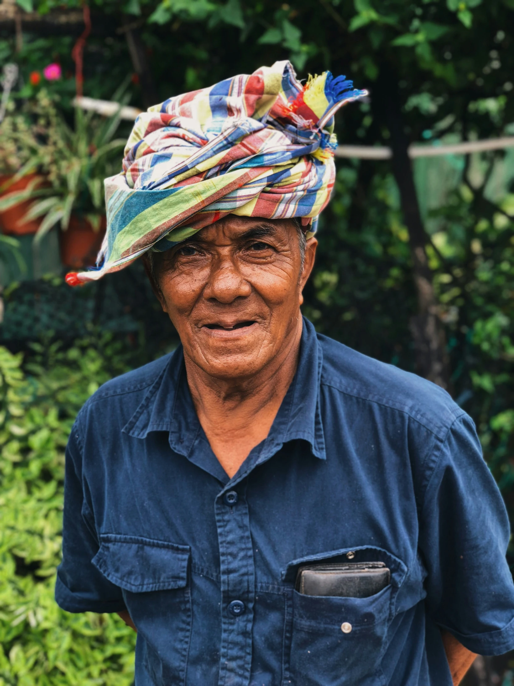 an old man wearing a colorful hat is smiling for the camera