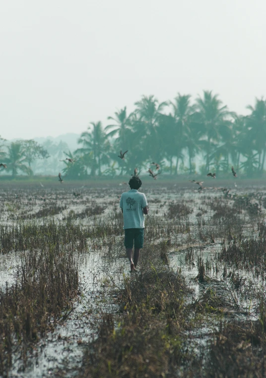 a man walking in the rain carrying a kite