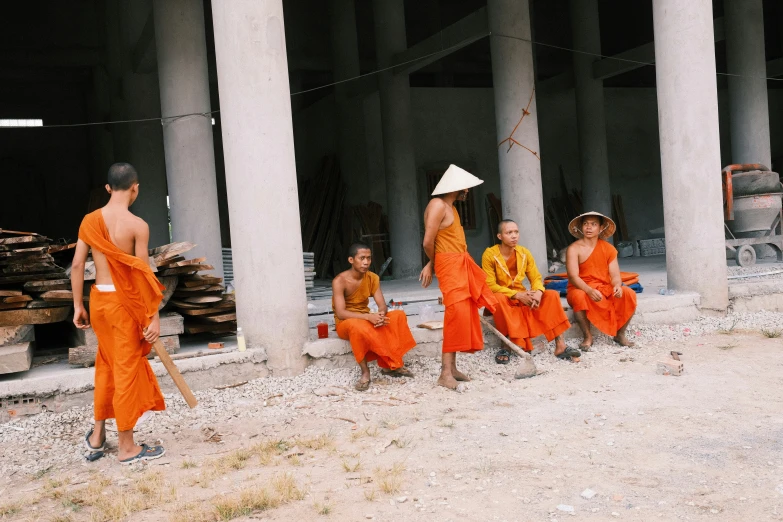 there are four monks that are sitting on the ground