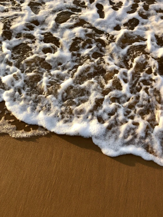 the waves crashing onto the sandy beach shore