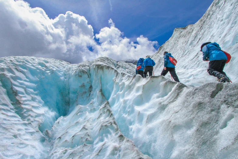 three people hiking up a steep snowy mountain side