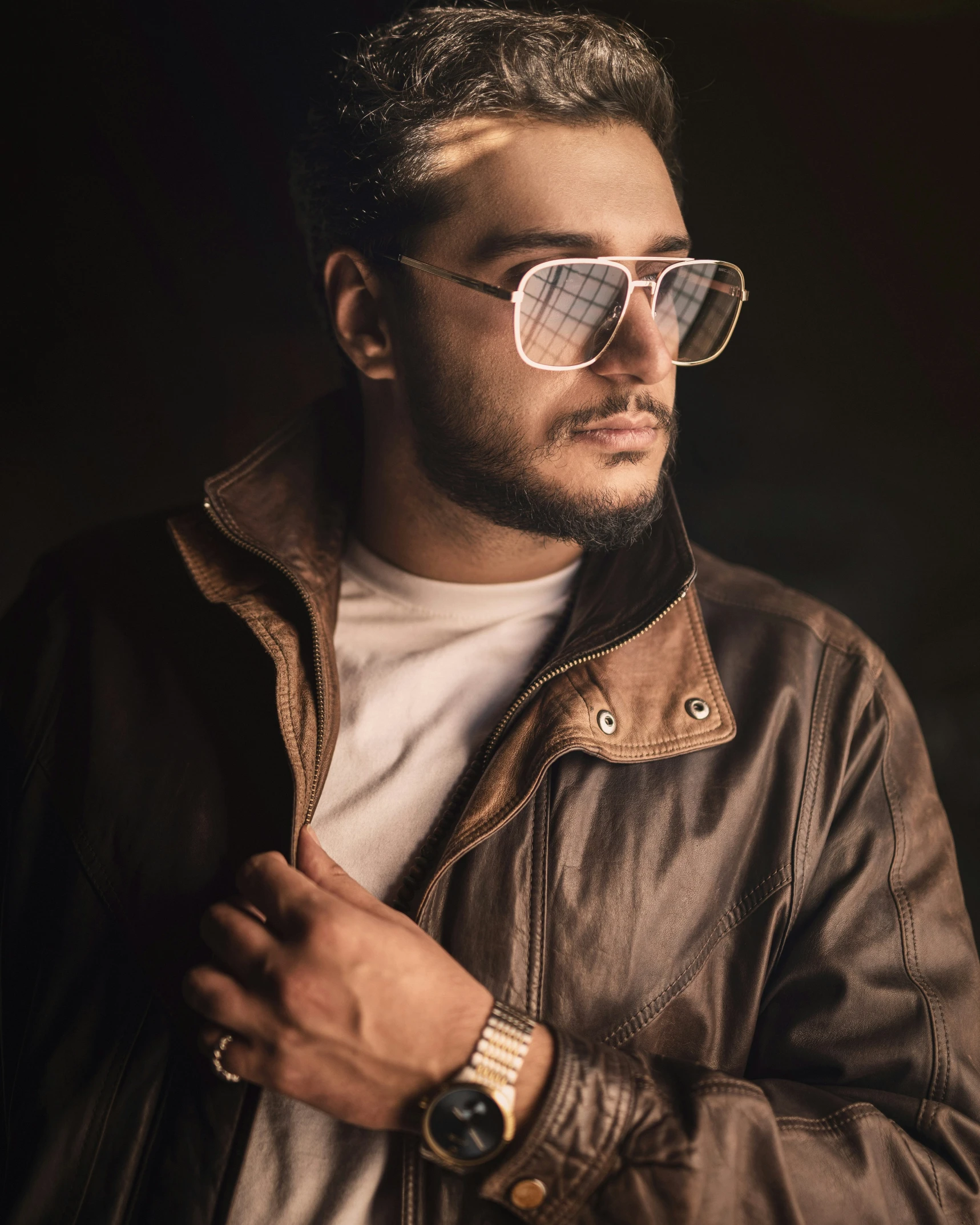 a man in a leather jacket, wearing gold watch