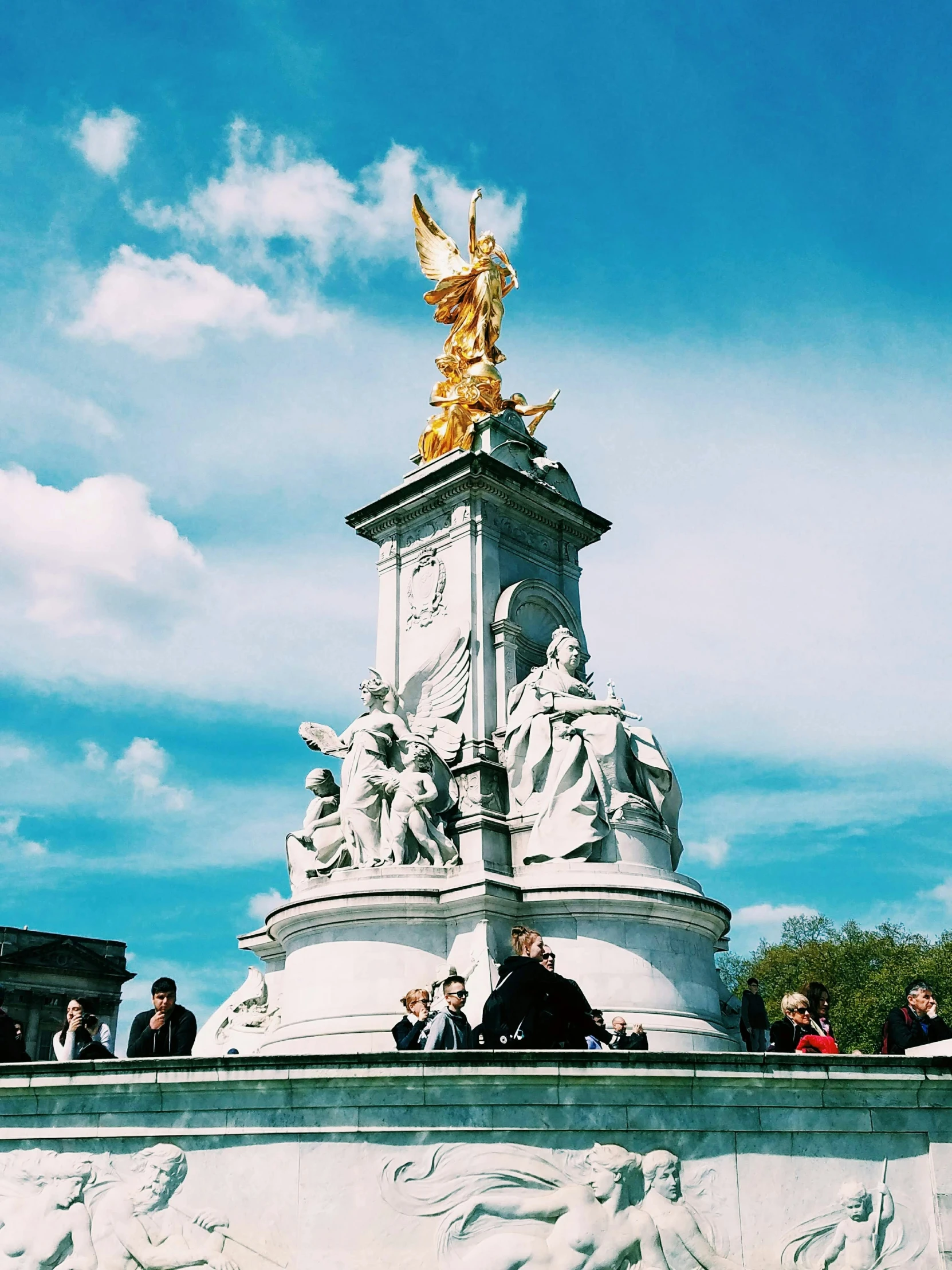 people gather around the base of a statue