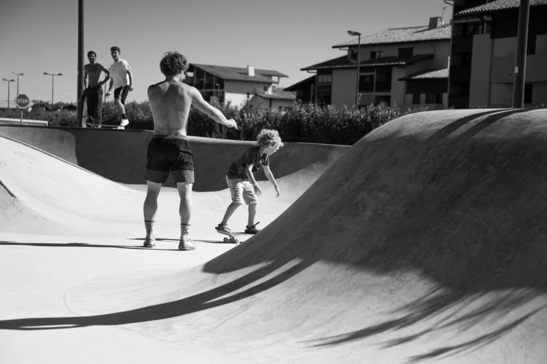 a black and white po of people skating on ramps