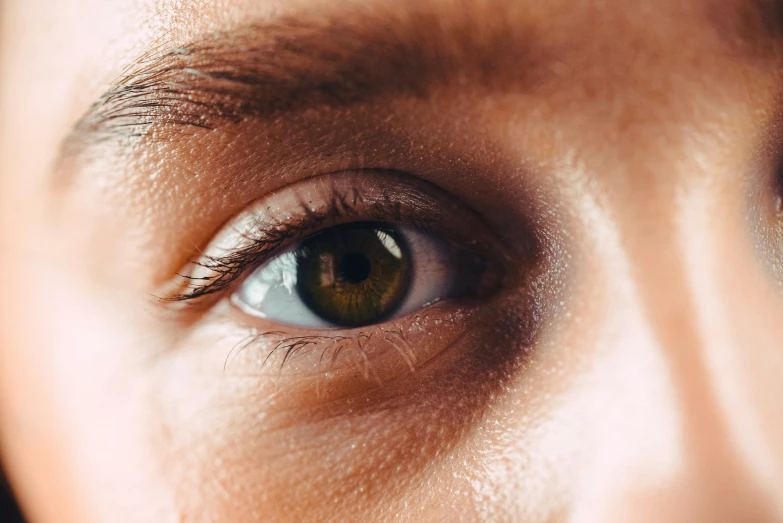 close - up of a person's green eye looking at soing