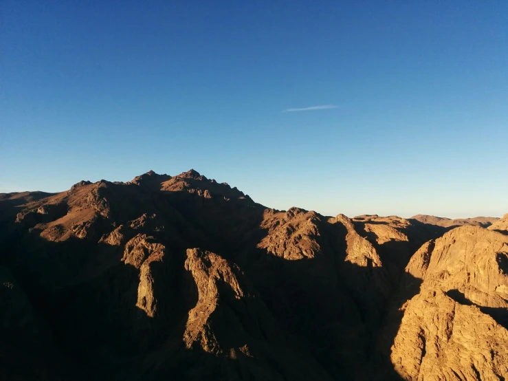 an airplane flying over the mountains of desert