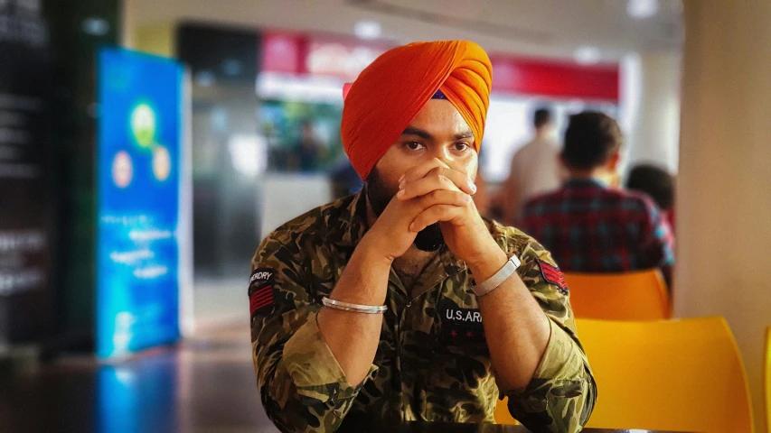 an indian man with a turban sitting at a table