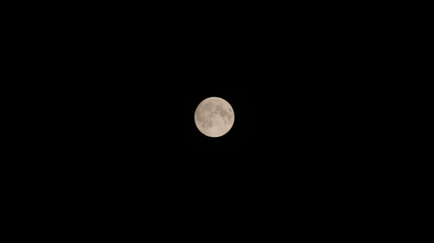 a full moon seen from the horizon of a dark sky