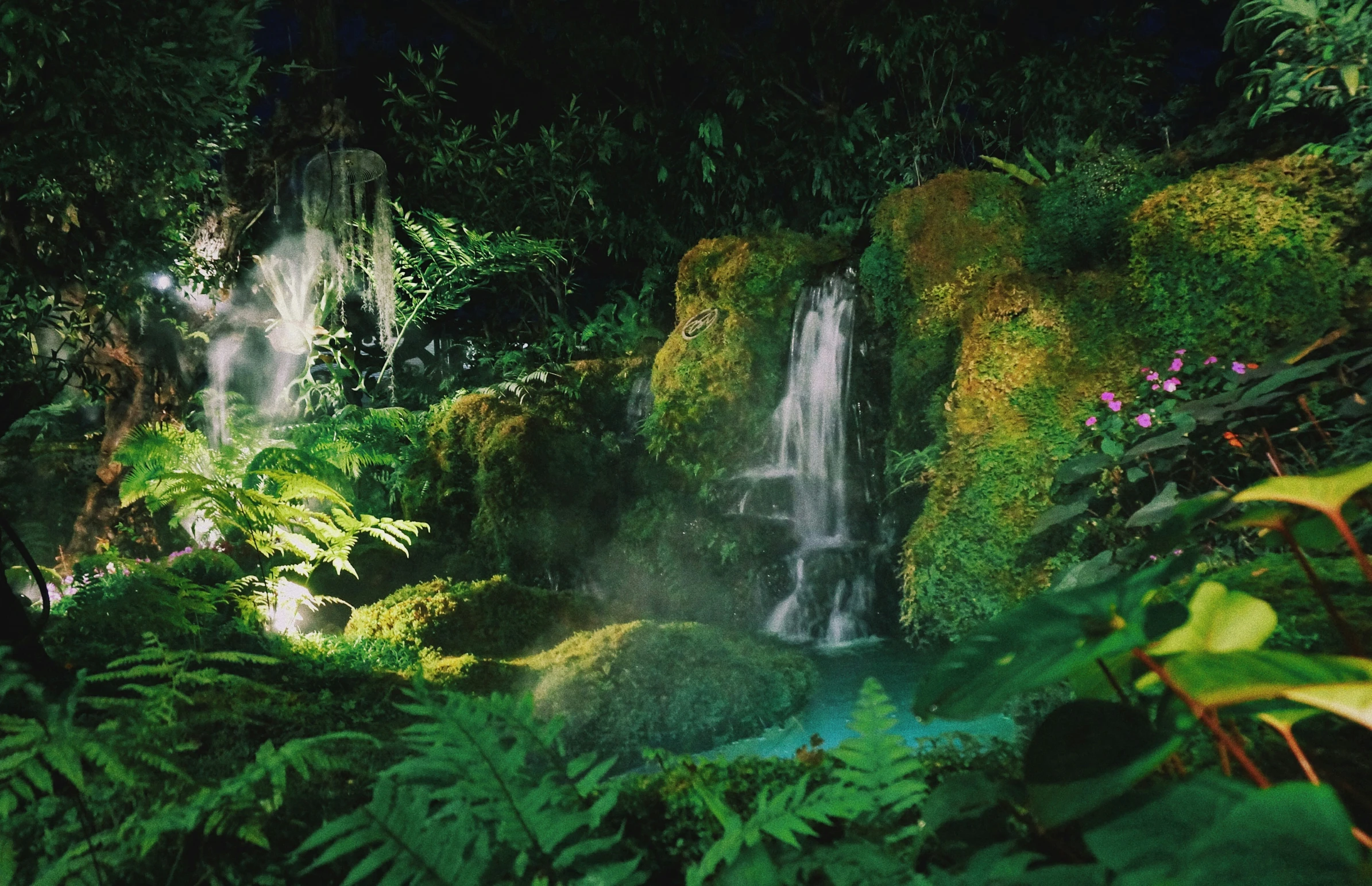 a very large waterfall that is in the middle of some plants