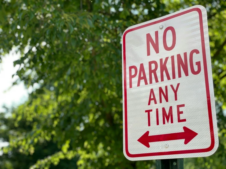 there is a street sign that says no parking any time