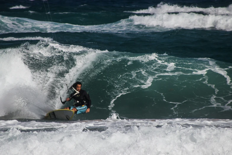 a man with a hat riding a wave on a surfboard